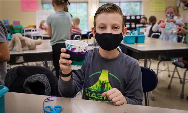 student creates woven craft